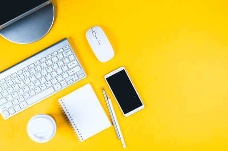 White keyboard, mouse and Notepad on yellow background. Flat lay and top view, copy space for textの写真素材