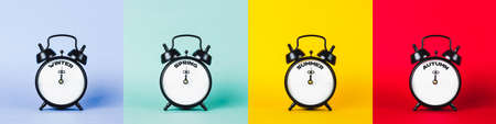 Photo collage of four seasons. Winter, spring, summer and autumn - text on black alarm clockの写真素材