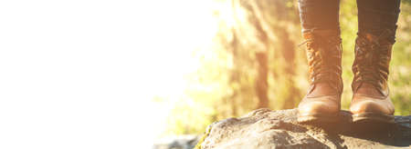 Female legs shod in Hiking boots on the forest background. Travel conceptの写真素材