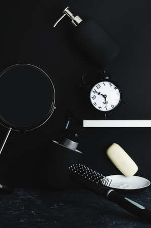 Morning hygiene supplies are scattered in disarray on a black background. The concept of the morning hustle and bustleの写真素材