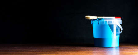 A can of blue paint and a brush on a wooden table. Space for text or designの写真素材