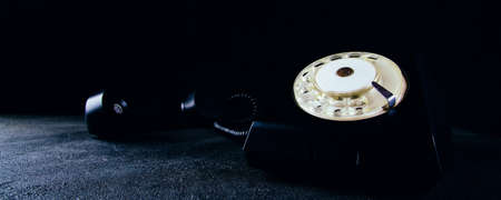 Vintage black dial phone on dark backgroundの写真素材