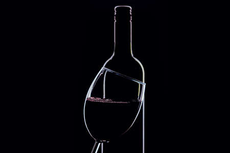 A glass of red wine and bottle on dark backgroundの写真素材