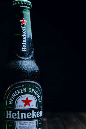 Russia, Moscow, July 11, 2020: Bottle of "Heineken" beer on a wooden table and dark backgroundのeditorial素材