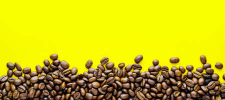 Ð¡offee beans on a bright yellow background. Copy space for text and panoramic frameの写真素材