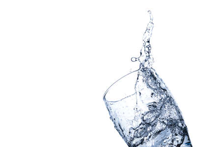 Water splashes in a transparent glass isolated on a white backgroundの写真素材