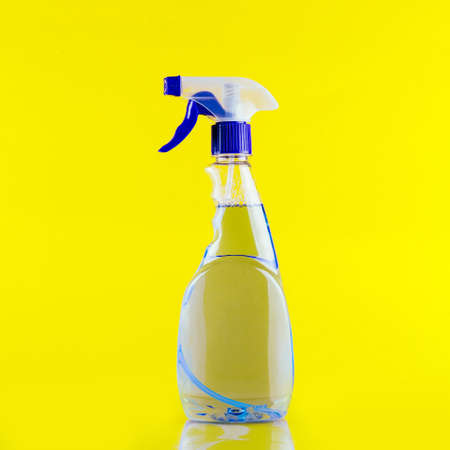 A bottle of cleaner with a white label on a yellow background. Template for text or designの写真素材