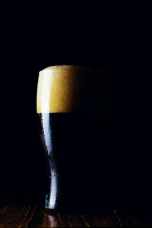 Porter beer mug with foam on a dark backgroundの写真素材