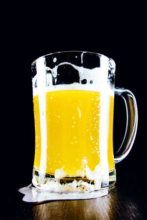 Lager unfiltered beer mug with foam on a dark backgroundの写真素材
