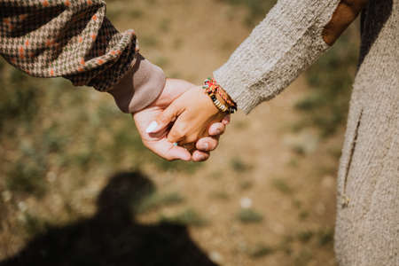 man and woman holding each others hands, close-up, in nature, outdoors, hugs, tenderness
