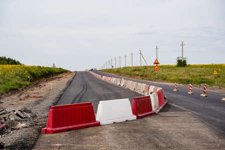 laying of new asphalt, road repairs, highways, road works, gravel, protective fences, marking, going into the distance, old and new, without peopleの写真素材