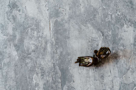 metal door handles in the shape of hands folded in mudra, shot on a textured gray background, close-up, separate object, yoga theme, bronze shade, Indian motifの写真素材