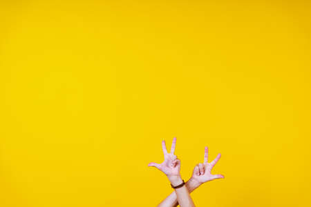 white male hands on a yellow background, fingers bentの写真素材