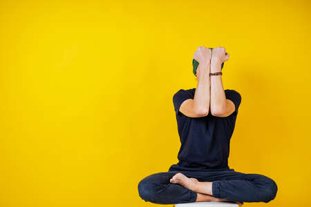 white male hipster doing yoga on a yellow background, yoga exercises and asanas, meditation, calm