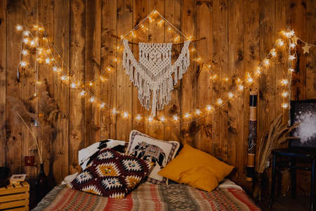 loft room on the second floor in a wooden style with lights, warm colors, interior design, bed on the floor, a cozy place to sleepの写真素材