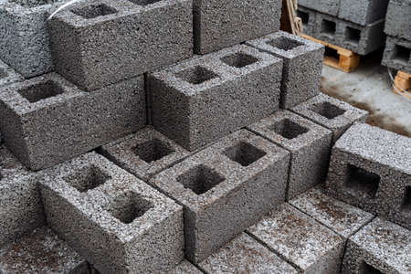 cinder blocks of gray concrete are neatly stacked in a pile, slender rows of bricks, material for building a houseの写真素材