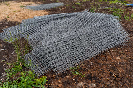 iron grid with square cells for the construction works, a metal grille folded in a pile