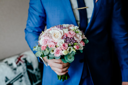 the groom holds the brides bouquet, the wedding bouquet on the background of the jacket, the wedding dayの写真素材