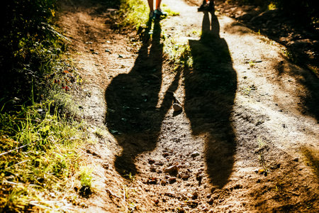 silhouette of a man and a woman, outdoors, shadows from peopleの写真素材