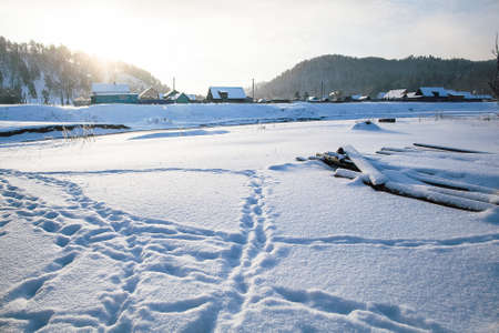 tire tracks in the snow, winter road, empty road in winter goes far to the horizon, covered with...