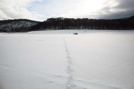 tire tracks in the snow, winter road, empty road in winter goes far to the horizon, covered with...