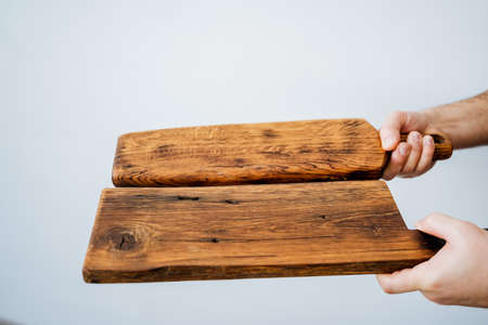 cutting board for cooking in the kitchen. a wooden board in the hands of a man. kitchenware. handmade carpenr's item. High quality photoの写真素材