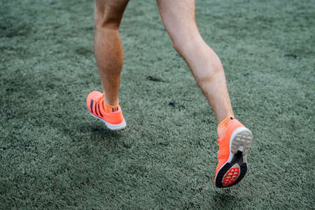 A close shot of the legs of a running man. Active recreation, sports and playing football. Bright...