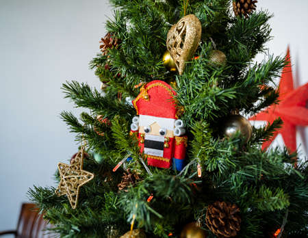 A toy nutcracker hangs on a holiday tree. Festive mood before the New Year and Christmas. Christmas...