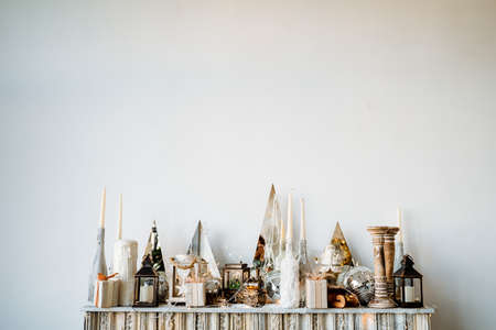 New Year's decor on a minimalist white background. Candles, toys, gift box and lamps. Christmas and...