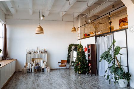 Interior shot. Two-storey room with large panoramic window, fireplace, decorated Christmas tree, preparations for the new year Modern apartment. High quality photoの写真素材