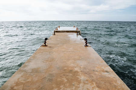 Iron pier in the endless sea. An old breakwater in the sea. A promising shot of the sea, clear skies and bright blue water. High quality photoの写真素材
