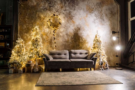 New Years interior of the room. Decorated Christmas trees with gifts. tinsel and garlands.Interior shot . Christmas and New Years moodの写真素材