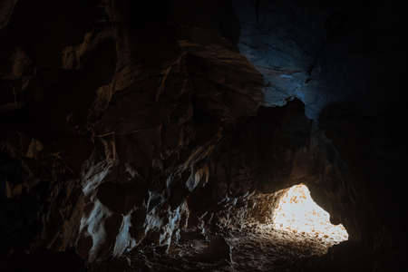 The light at the end of the tunnel. Exit from the cave. Dark passage in the dungeon. Speleotourism.の写真素材