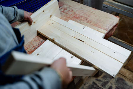 Wood processing. Work in the carpenter's workshop.Cutting a wooden bar. Installation for sawing...