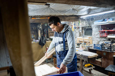 Craft. A carpenter processes wood in a workshop. Wood products. Tools for wood carving. A joiner...