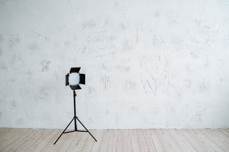 Studio light on the stand stands on a minimalist background. Equipment for photo studio, interior shooting.の写真素材