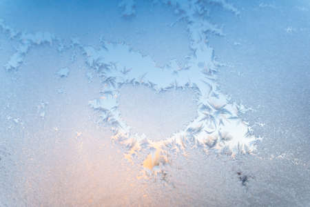 The texture of the glass covered with frost in winter in cold. Magical winter patterns. Natural...