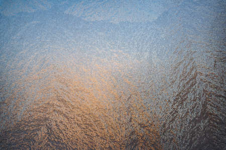 Magical frost and ice patterns on a winter glass. Natural phenomena. Winter decorations, frozen water on the window.の写真素材