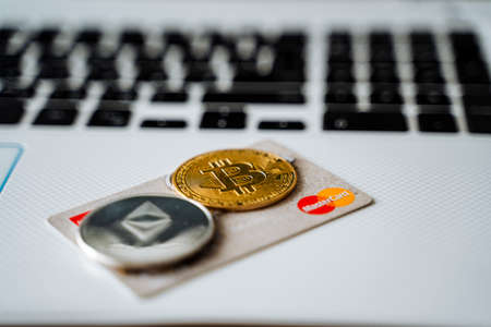 Russia Ufa February 2022: Credit card mastercard and two cryptocoins bitcoin, Ethereum. Cryptocurrency is accepted on a bank card. high quality photoのeditorial素材