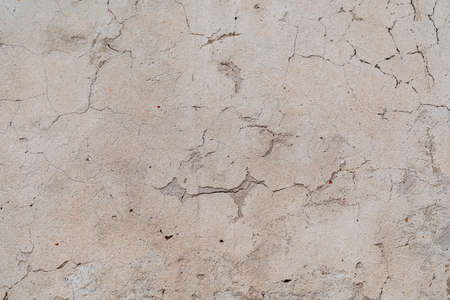 An old shabby wall with cracks. Peeling plaster. Street walls of the old building. Renovation of...