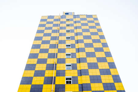Panoramic view of the new residential building. Bright facade of the house of panels. The facade design is a chessboard. Modern apartment building with an unusual design. high quality photoの写真素材