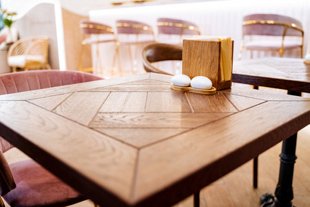 Wooden table in the cafe Napkin stand White salt shaker and pepper shaker. high quality photoの写真素材