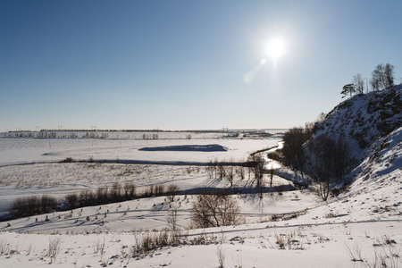 Bright sunlight against the sky. Winter landscape in Russia, blue lake Bashkortostan, Nature of the...