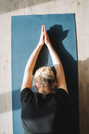Balasana view from above, the child's posture for complete relaxation of the body, the girl practices yoga lying on the mat. high quality photoの写真素材