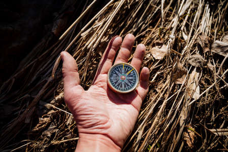 The compass lies on the open palm of the arrow points to the north, the cardinal points, the magnetic pole of the earth, retro style, the hand of man. high quality photoの写真素材