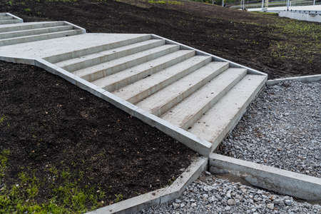 A new pedestrian staircase in the park, landscaping of the city park, concrete steps, stairs on the ground, repair of the pedestrian part of the road, a restrictive curb of the sidewalkの写真素材