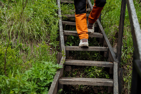 Hiking shoes, wooden stairs in nature, close-up feet, walking steps in the forest, trekking shoes, hiking. high quality photoの写真素材