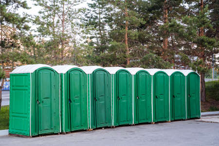 a variety of urban cabins of composting toilets, an outdoor toilet of green color, a plastic eco-toilet stands on the asphalt, a bunch of booths. high quality photoの写真素材
