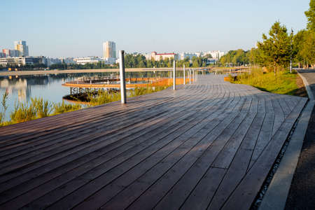 A road of boards, a wooden platform, a pedestrian path, a park in the city by the lake, a river...