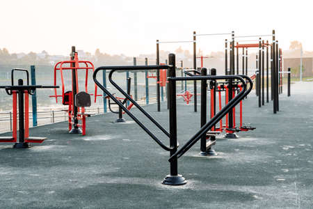 Sports ground, outdoor exercise machines, metal bars, fitness training in the open air, no people, morning dawn. high quality photoの写真素材
